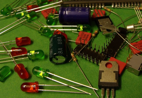 Verschiedene elektronische Bauteile wie LEDs, Kondensatoren, ICs und Widerstände